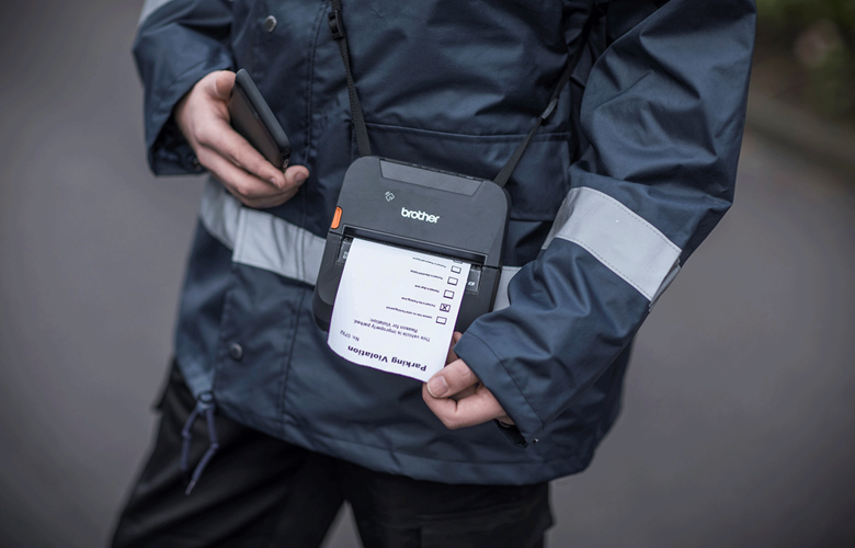 Parking attendant printing parking ticket from RJ printer on shoulder strap